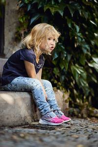 Young woman looking away while sitting outdoors