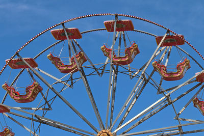 Low angle view of ferris wheel against clear blue sky