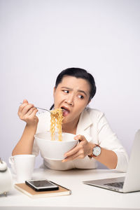 Young woman using laptop in coffee cup on table