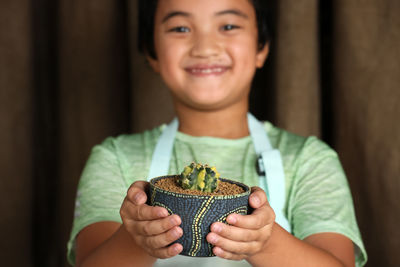 Portrait of smiling boy holding plant