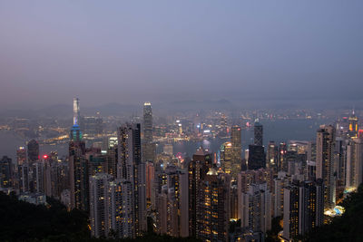 Illuminated buildings in city against sky