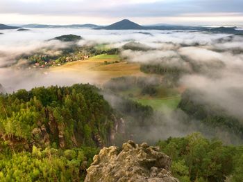 Spring mist. morning in beautiful hills of natural park. rocky peaks increased from creamy fog.