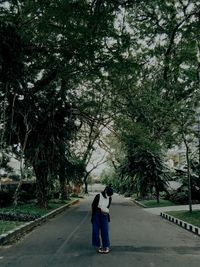 Rear view of woman walking on road