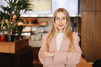 Portrait of a businesswoman entrepreneur with glasses looking at the camera in a public place 