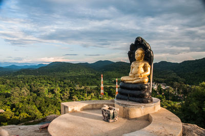 Buddha statue against mountain against sky