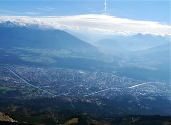 Aerial view of townscape and mountains against sky