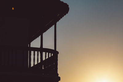 Low angle view of silhouette balcony against sky during sunset