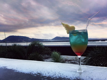 Close-up of drink on ice against sky