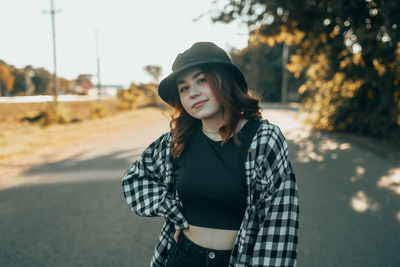 Young woman standing against trees