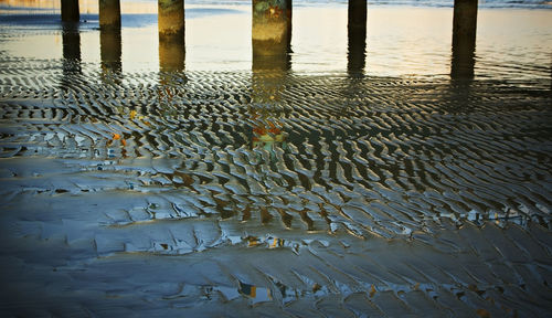 High angle view of wet wooden post in lake during sunset