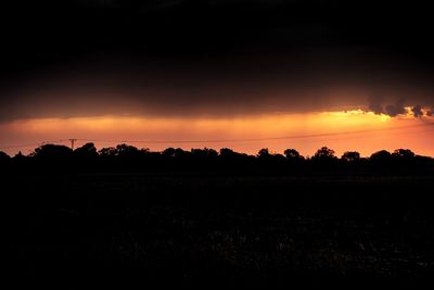 Scenic view of silhouette field against sky during sunset