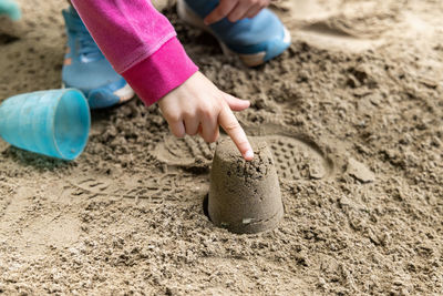 Close-up of child playing on sand at beach