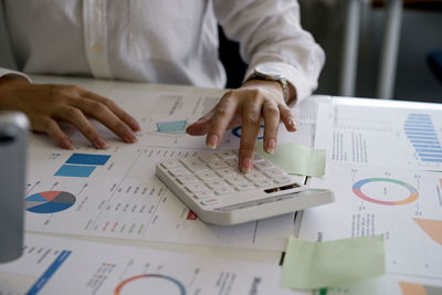 Midsection of business people working on table