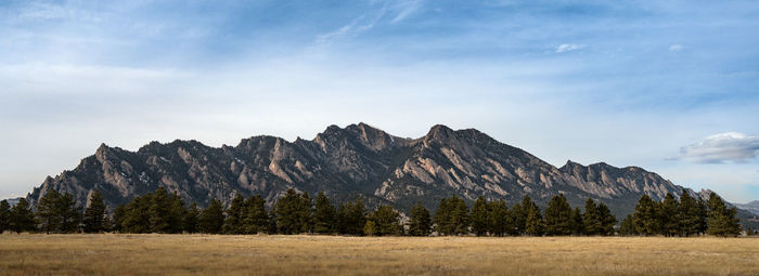 Mountains rise above the planes. a panorama of the flatirons in boulder, colorado.