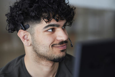 Smiling man wearing headset looking away