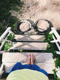 Low section of woman standing on steps at beach