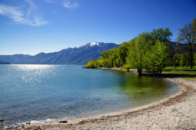 Scenic view of lake and mountains against blue sky