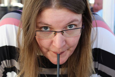 Close-up portrait of mature woman drinking with straw