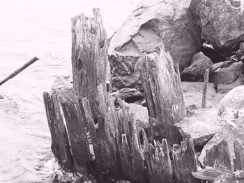 Close-up of frozen rock on shore against sky