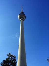 Low angle view of fernsehturm tower against blue sky