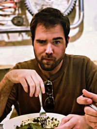 Portrait of young man sitting in restaurant