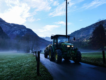 Panoramic view of road amidst field against sky