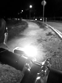 Close-up of person with bicycle on road at night