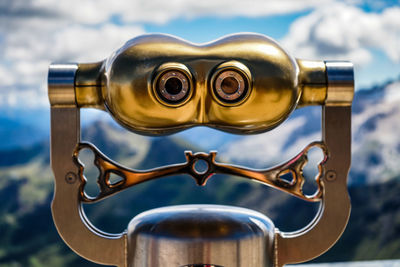 Close-up of coin-operated binoculars against sky