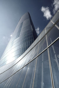 Low angle view of modern glass building against sky