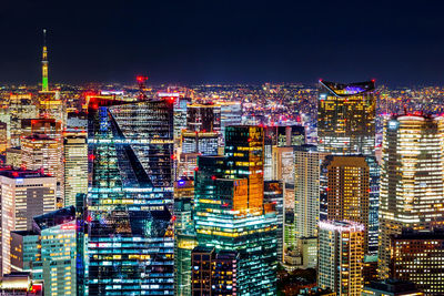 Illuminated buildings in city against sky at night