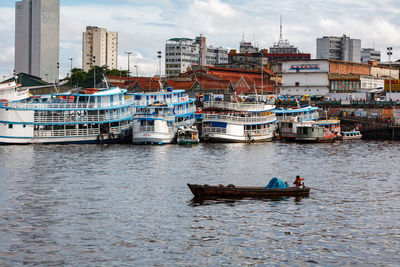 Fishing boats in river in city