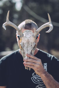 Close-up of man holding animal skull