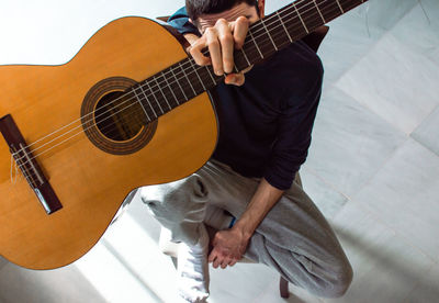 Midsection of man playing guitar