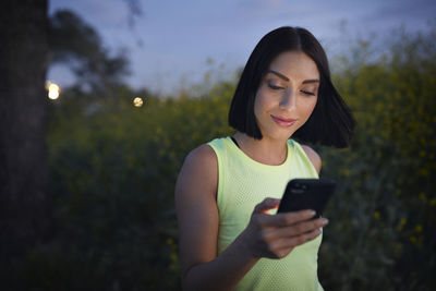 Jogger text messaging on smart phone during sunset