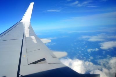 Airplane flying over clouds against blue sky