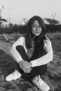 Portrait of smiling woman sitting on land