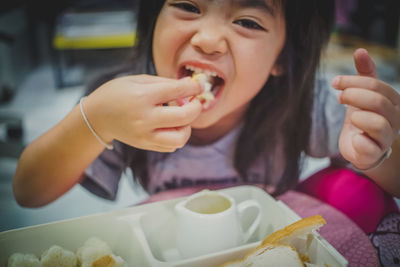Close-up of girl eating bread