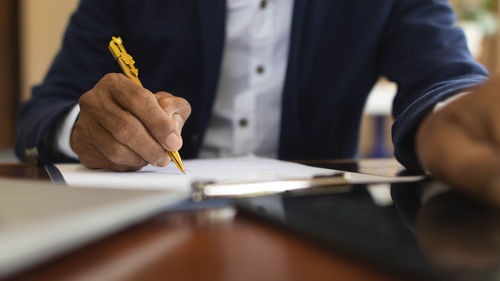 Midsection of businessman working on table