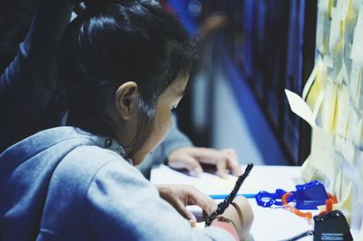 Close-up of girl writing on table