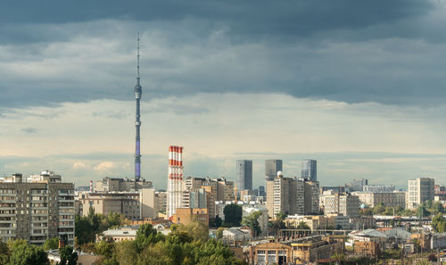 Modern buildings in city against cloudy sky