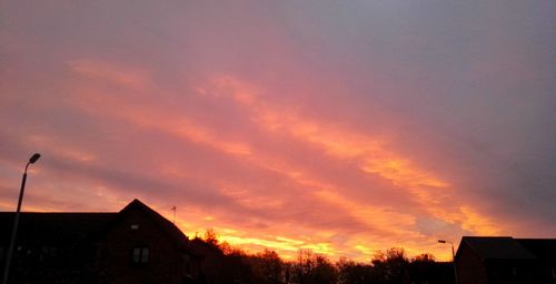 Low angle view of silhouette buildings against sky during sunset