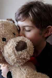 Young boy holding a soft stuffed dog at home