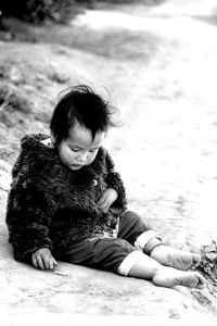 Baby hmong playing on dirty ground in chiang mai thailand