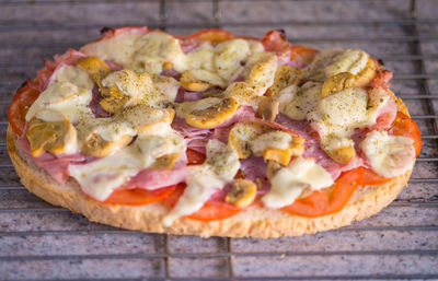 Close-up of pizza on cooling rack at table