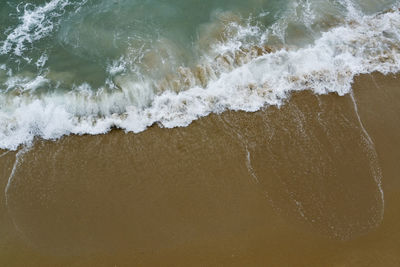 High angle view of waves rushing towards shore