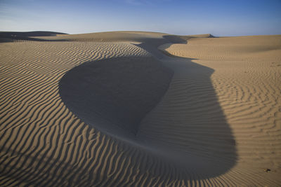 Shadow of sand dune in desert