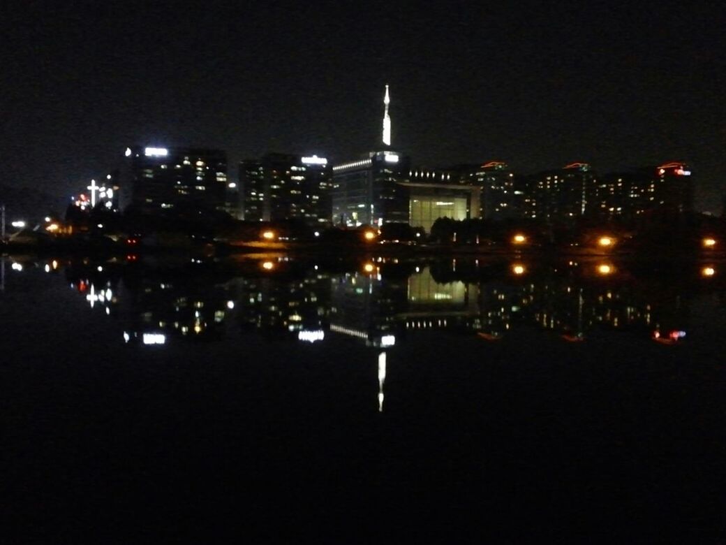 night, illuminated, building exterior, city, water, architecture, built structure, cityscape, reflection, waterfront, river, sea, dark, clear sky, skyscraper, copy space, high angle view, urban skyline, no people, outdoors