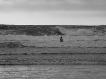 Man surfing in sea against sky