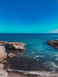 Scenic view of sea against clear blue sky