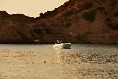 View of boats in sea against mountain range